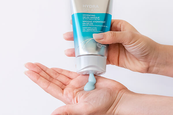 HydraSplash-masque-in-hand Hair styling product being squuezed out of bottle